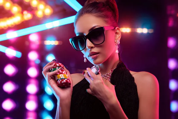 A young woman relaxing with her phone while dynamic casino elements float around her, illustrating the smooth mobile experience offered by the D63 app.